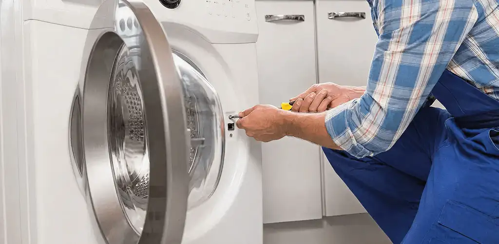 Handyman repairing a clothes dryer and checking electrical connections in Cape Coral, FL