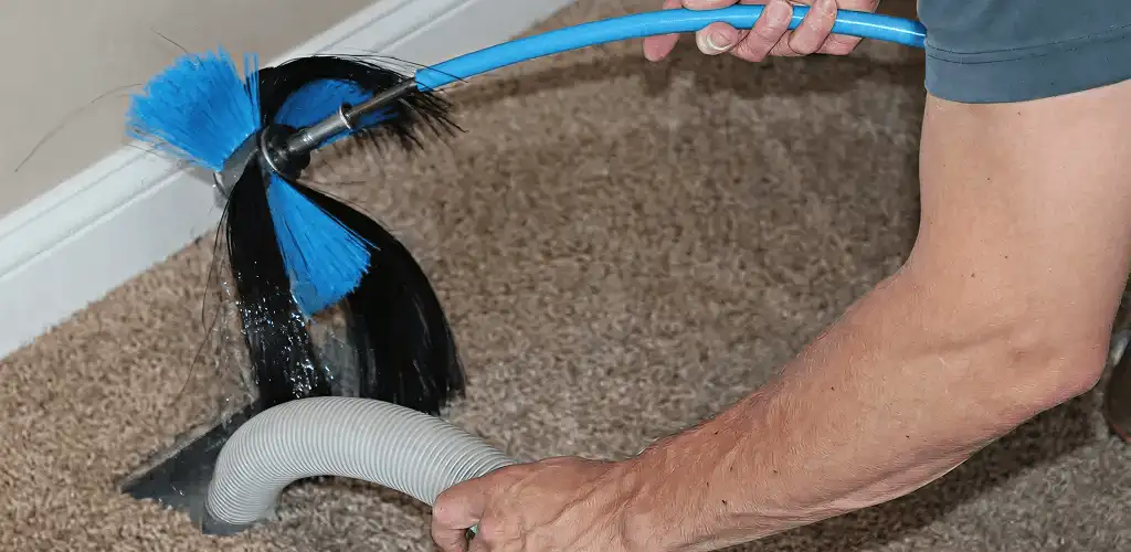 Dryer vent cleaning technician brushing lint from a vent line in Cape Coral, FL