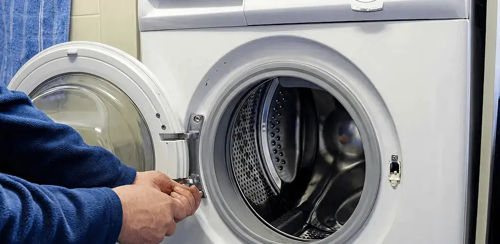 Washing machine repair handyman checking a front-load washer door and latch in Cape Coral, FL