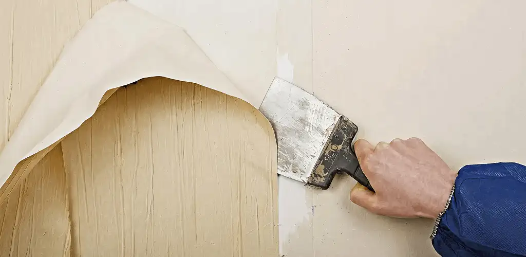 Handyman removing wallpaper with a scraper for wall preparation in Cape Coral, FL