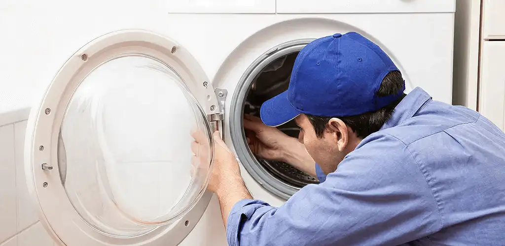 Washing machine repair handyman inspecting a front-load washer drum in Cape Coral, FL