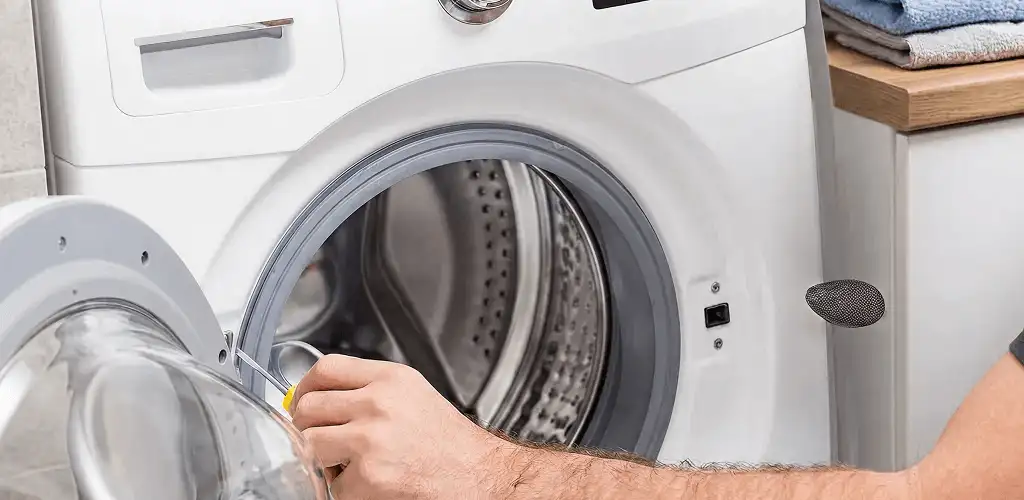 Handyman repairing a front-load washing machine and inspecting the drum in Cape Coral, FL