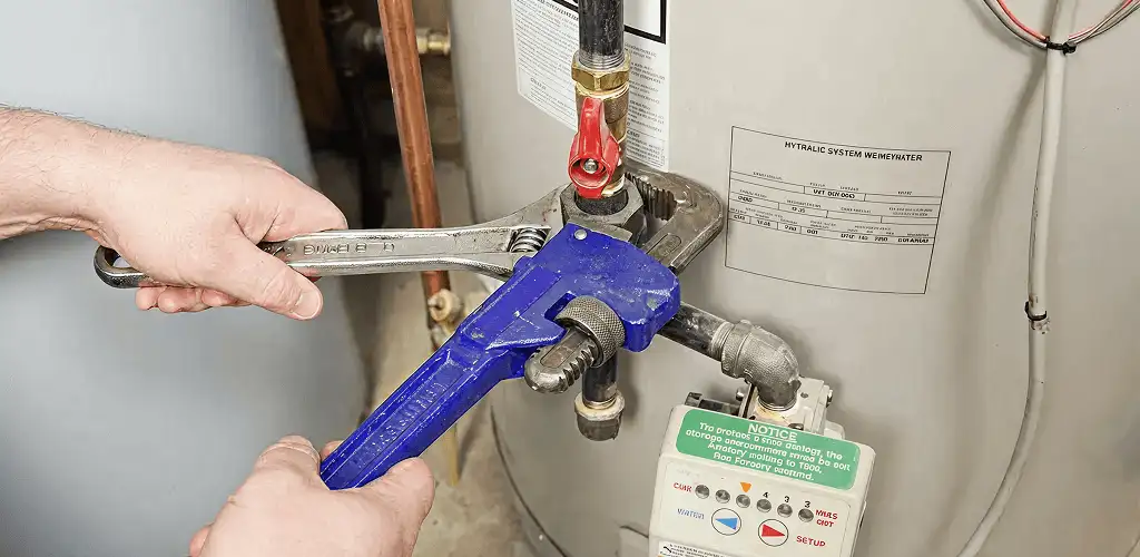 Water heater repair technician tightening the shutoff valve and supply line in Cape Coral, FL